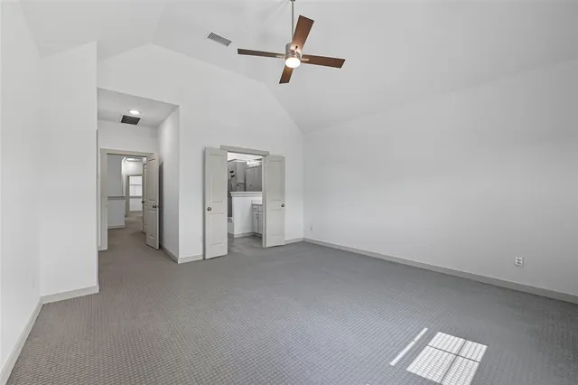 an empty room with a window and a ceiling fan