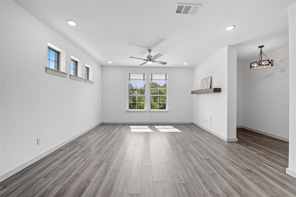 228 Spring Hill Road Flower Mound, TX 75028 - Photo 7 of 31 an empty room with wooden floor chandelier and windows