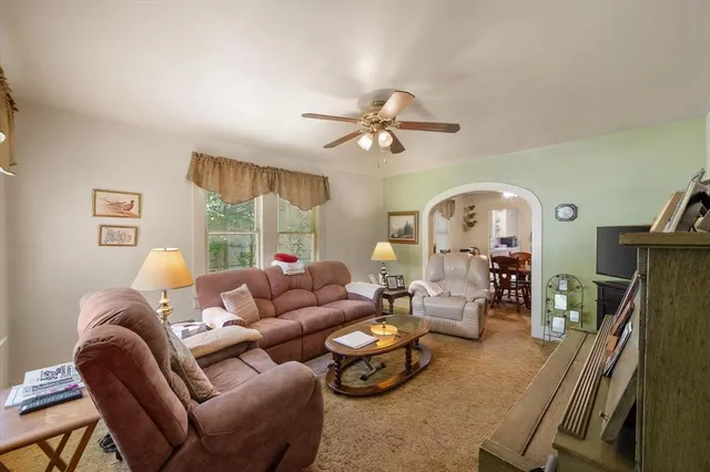 a living room with furniture a fireplace and a chandelier