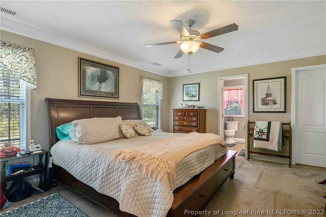 2511 Wade-Stedman Road Stedman, NC 28391 - Photo 19 of 47 a bedroom with a large bed and a chandelier