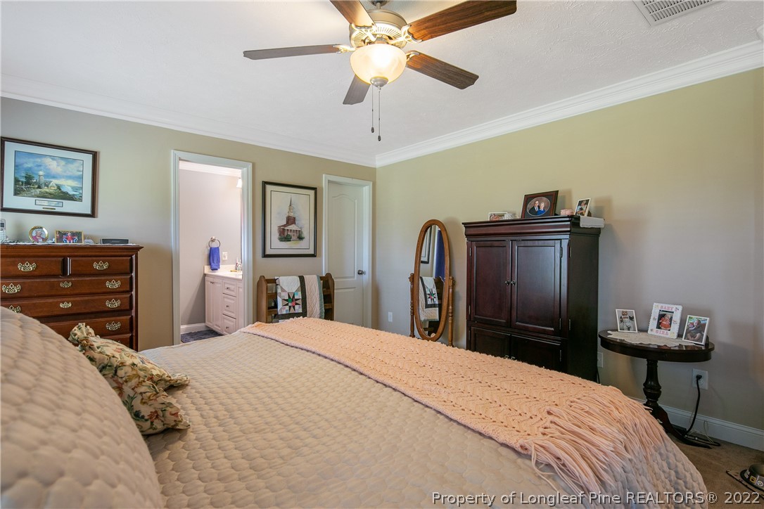 2511 Wade-Stedman Road Stedman, NC 28391 - Photo 20 of 47 a bedroom with a bed and a chandelier