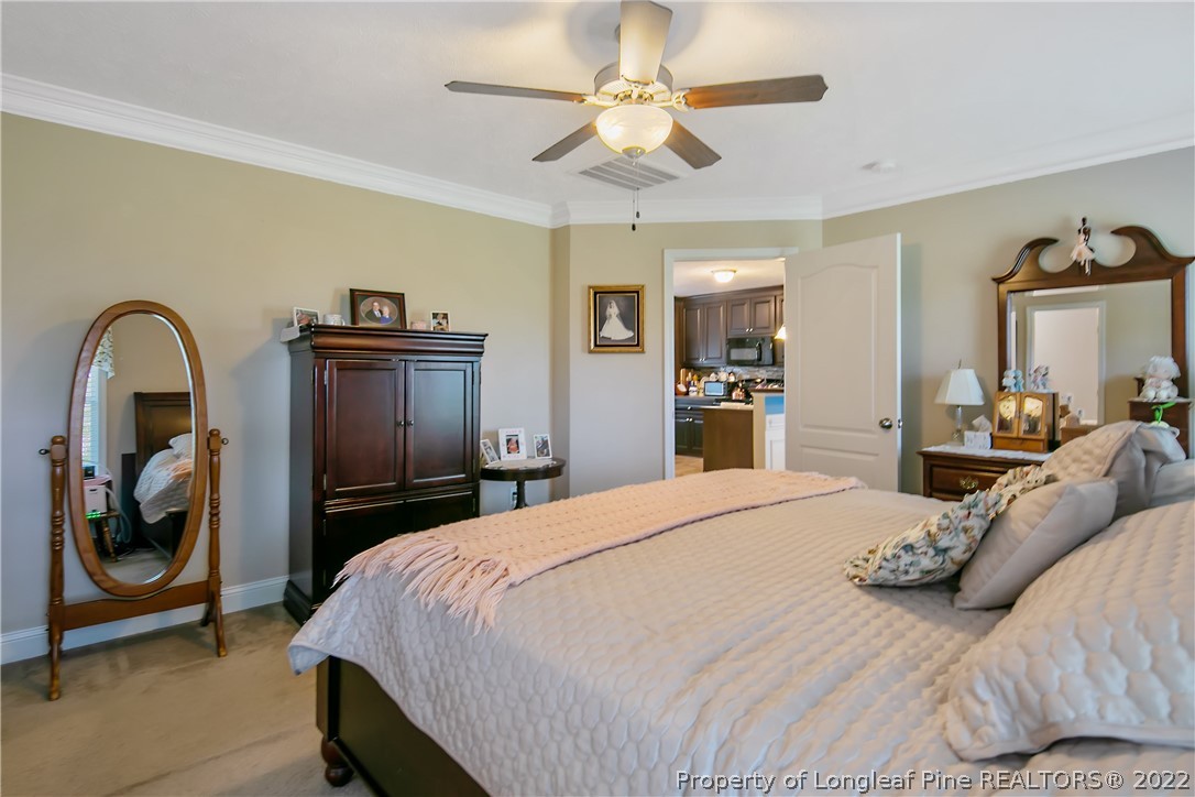 2511 Wade-Stedman Road Stedman, NC 28391 - Photo 21 of 47 a bedroom with a bed and a chandelier