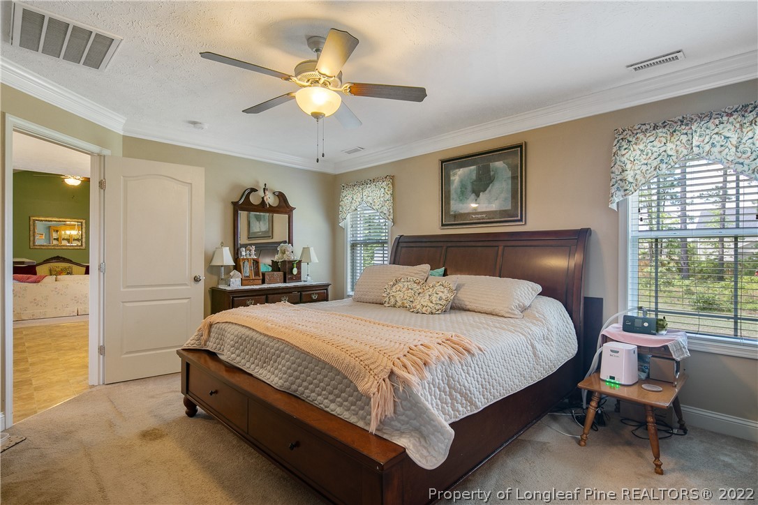 2511 Wade-Stedman Road Stedman, NC 28391 - Photo 22 of 47 a bedroom with a bed and a chandelier