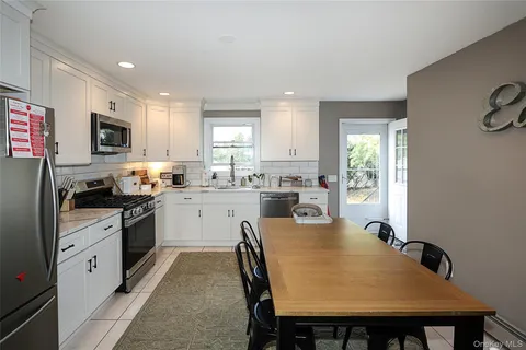 a kitchen with a table chairs microwave and cabinets