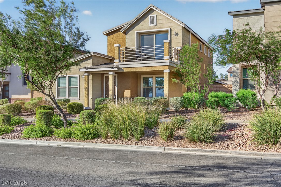 1100 East Sunset Road Henderson, NV 89011 - Photo 1 of 58 A contemporary exterior boasts an upper-level balcony and a welcoming porch, nestled amidst vibrant landscaping.