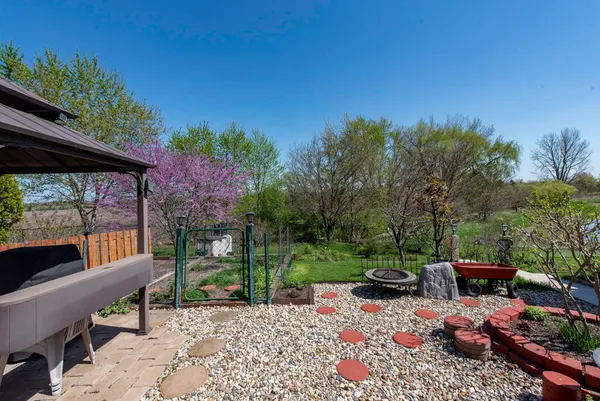 a view of a patio with table and chairs under an umbrella with a patio