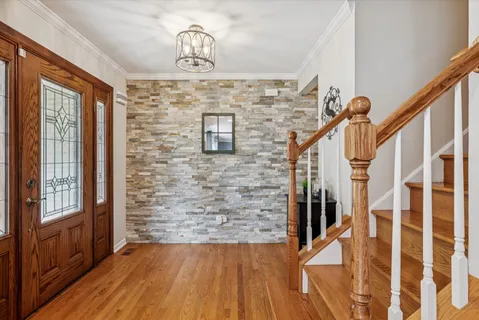 a view of a hallway with wooden floor and staircase