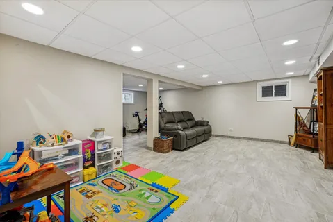 a living room with furniture and a baby crib