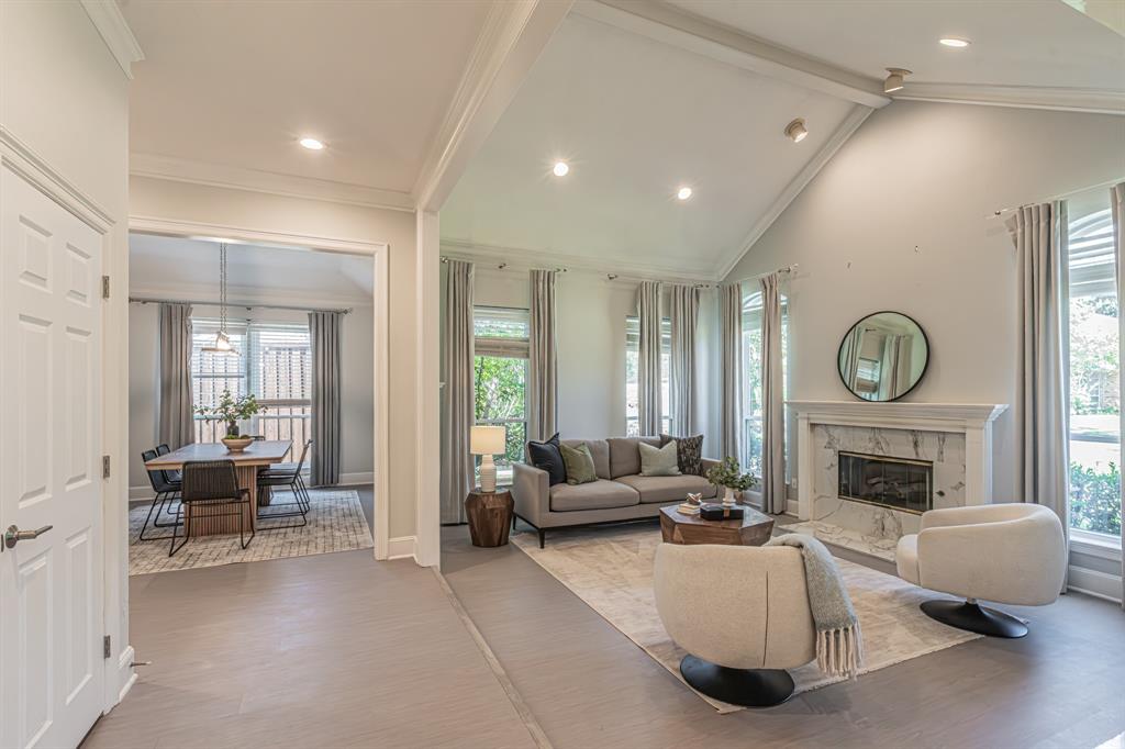 300 Sundance Circle Irving, TX 75063 - Photo 4 of 39 Living area with vaulted ceilings, recessed lighting, a fireplace with a stone surround, and large windows