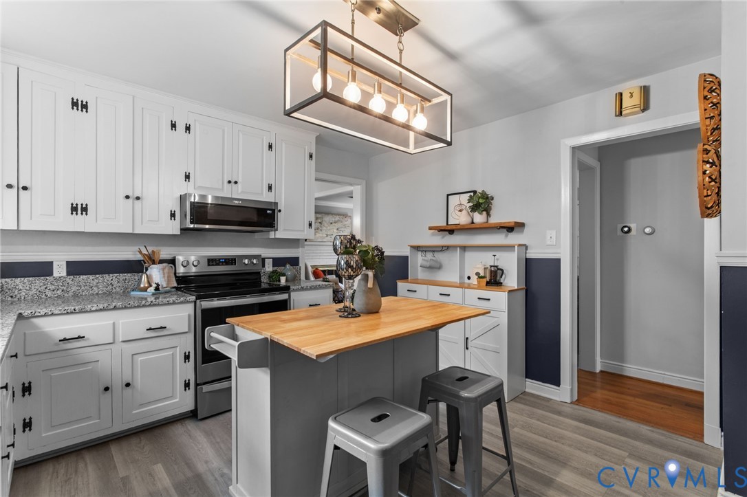 3819 Wakefield Road Richmond, VA 23235 - Photo 18 of 49 a kitchen with stainless steel appliances a stove a sink dishwasher and a refrigerator with wooden floor