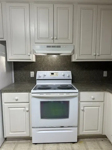 a stove top oven sitting inside of a kitchen