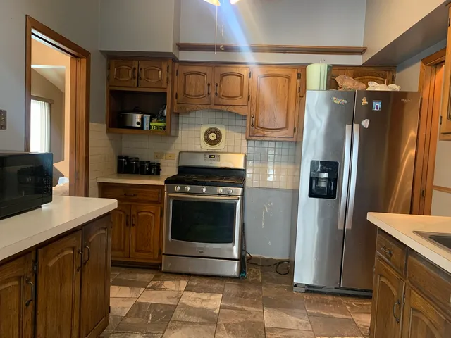 a kitchen with stainless steel appliances a stove a sink and a refrigerator