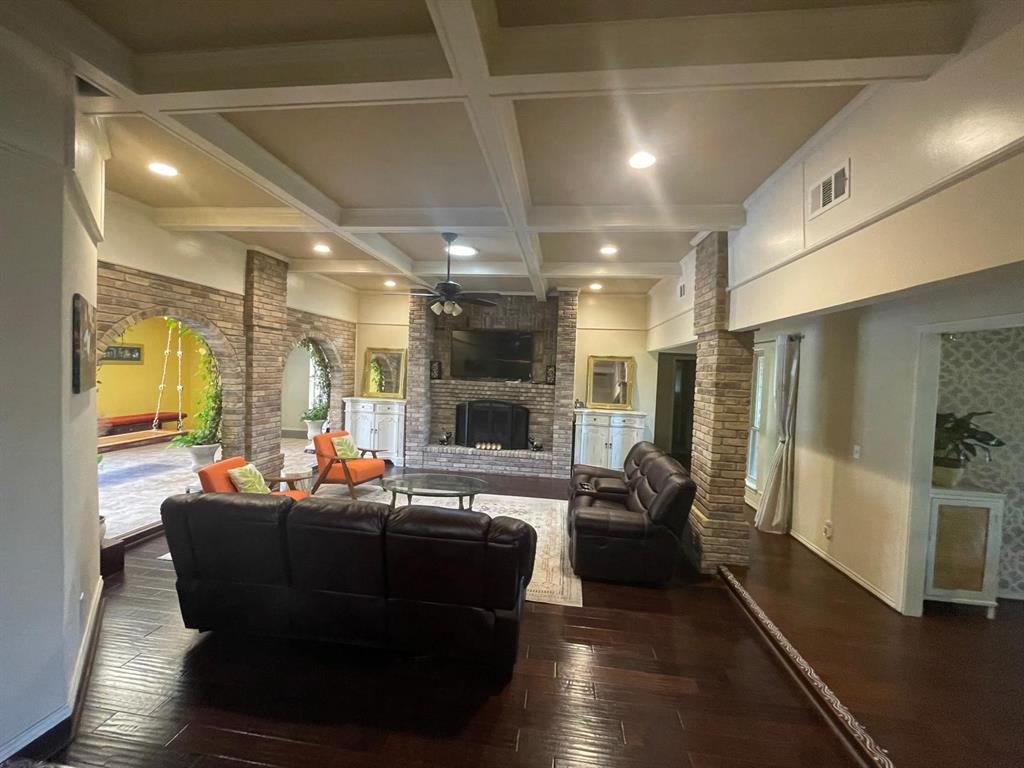3612 Cross Bend Road Plano, TX 75023 - Photo 13 of 38 Living room featuring beamed ceiling, coffered ceiling, dark wood-type flooring, and a fireplace