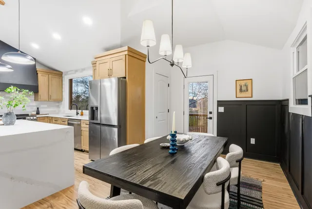 a view of a dining room with furniture a chandelier and wooden floor