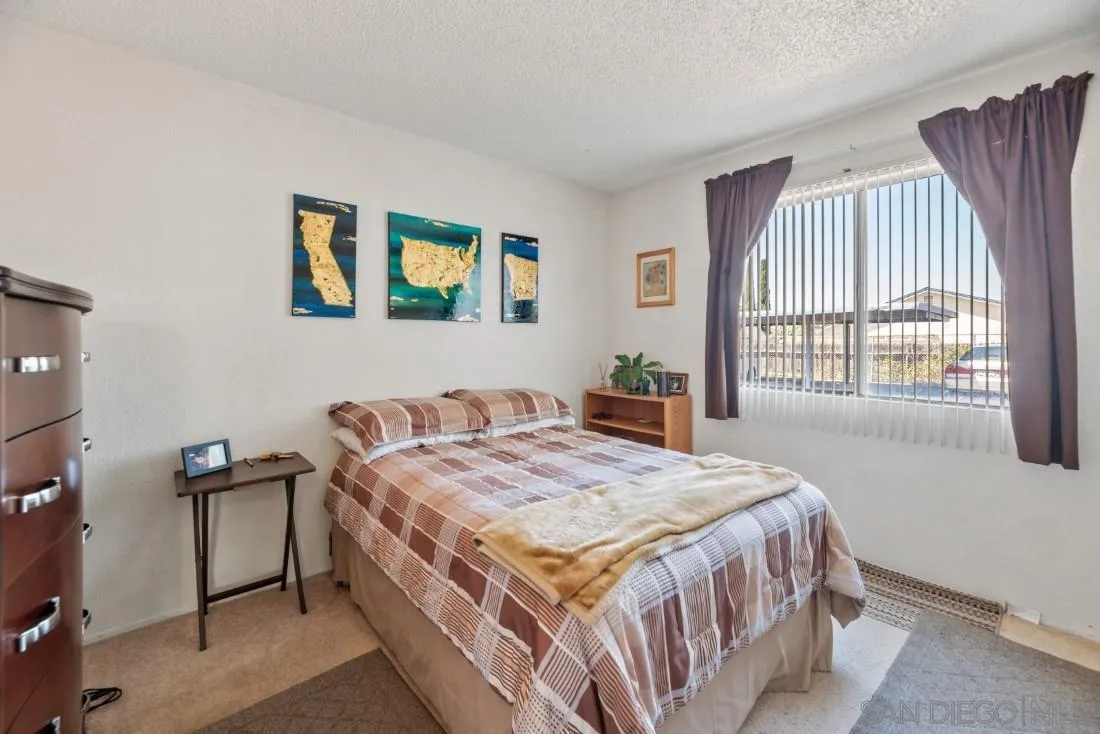 11187 Kelowna Road, Unit 74 San Diego, CA 92126 - Photo 11 of 24 a bedroom with a bed and a table in it with window