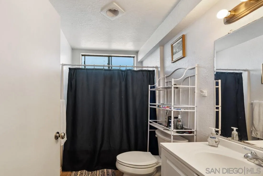 11187 Kelowna Road, Unit 74 San Diego, CA 92126 - Photo 14 of 24 a bathroom with a sink a toilet a shower and a mirror