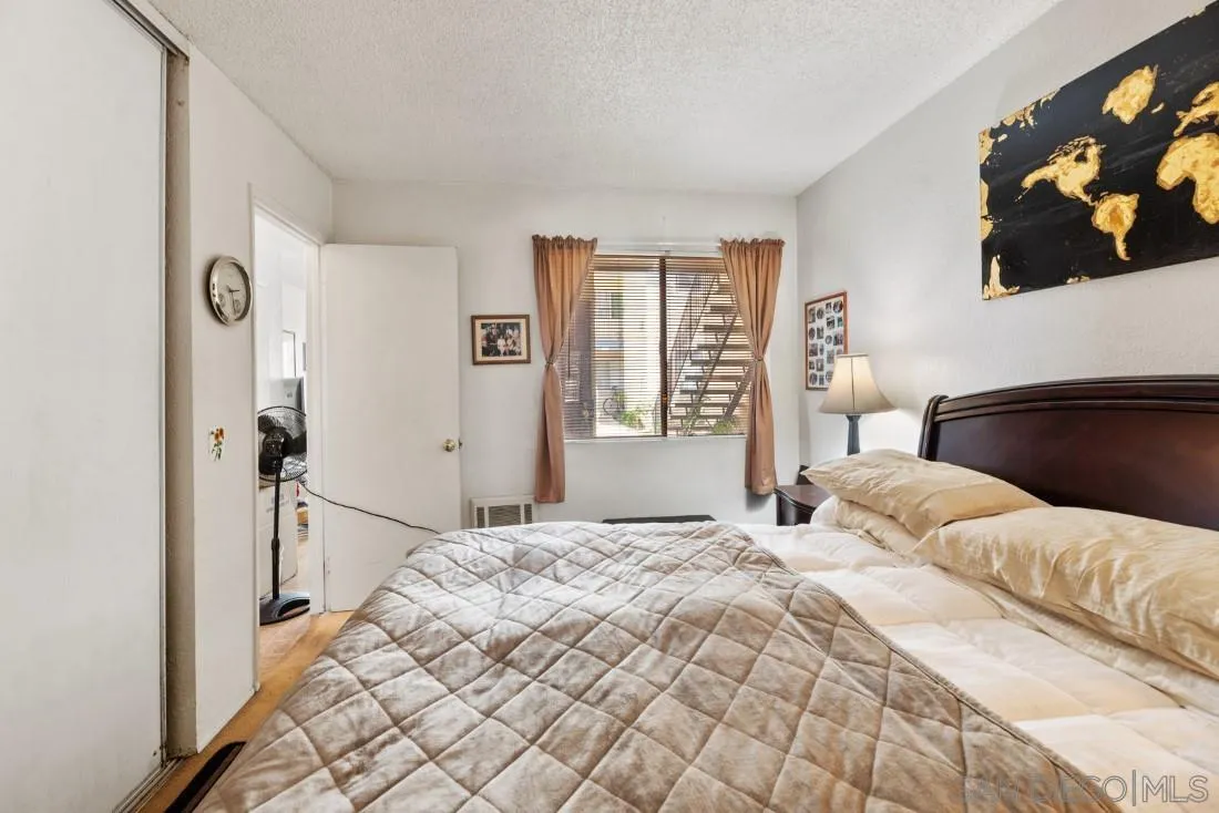 11187 Kelowna Road, Unit 74 San Diego, CA 92126 - Photo 17 of 24 a bedroom with a large bed and a chandelier
