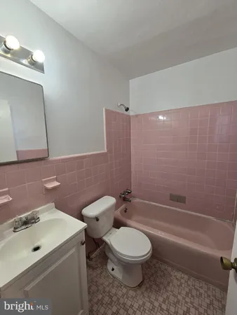 a bathroom with a toilet a sink a mirror and bathtub