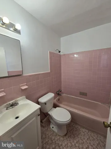 a bathroom with a toilet a sink a mirror and bathtub