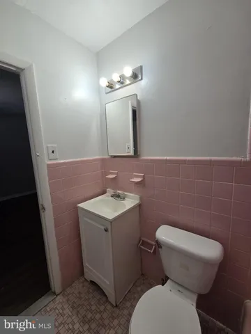 a bathroom with a toilet a sink and mirror