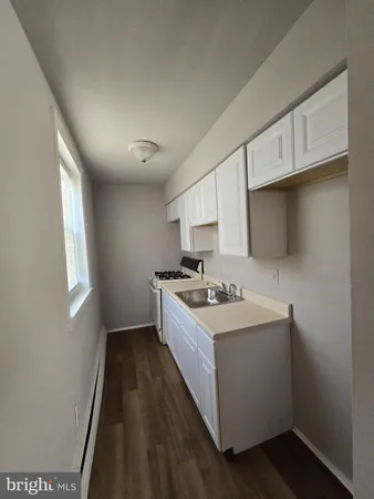 a kitchen with a sink stove top oven and cabinets