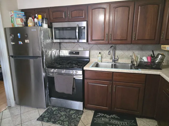 a kitchen with stainless steel appliances granite countertop a refrigerator a stove a sink and dishwasher