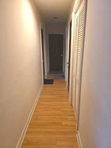 a view of a room with wooden floor and a window