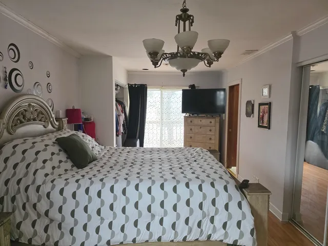 a bedroom with a bed and dresser with mirror