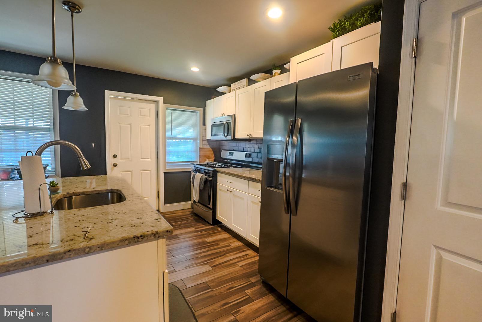 3915 Flowerton Road Baltimore, MD 21229 - Photo 4 of 17 a kitchen with stainless steel appliances granite countertop a refrigerator a sink and a stove