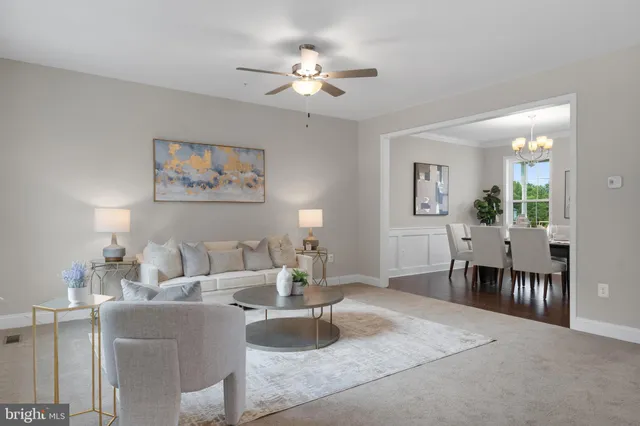 a living room with furniture two window and a dining table