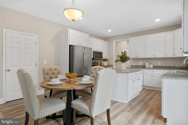 a kitchen with refrigerator and chairs