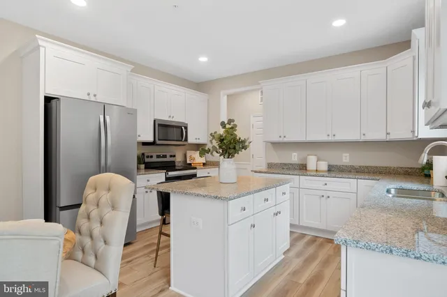a kitchen with stainless steel appliances granite countertop a refrigerator sink and stove