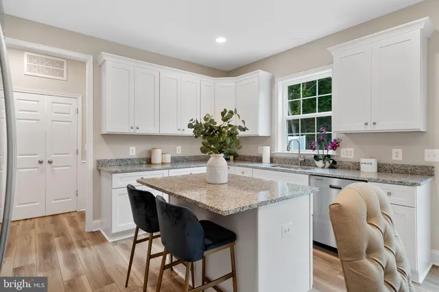 a kitchen with stainless steel appliances granite countertop white cabinets granite counter tops and a window