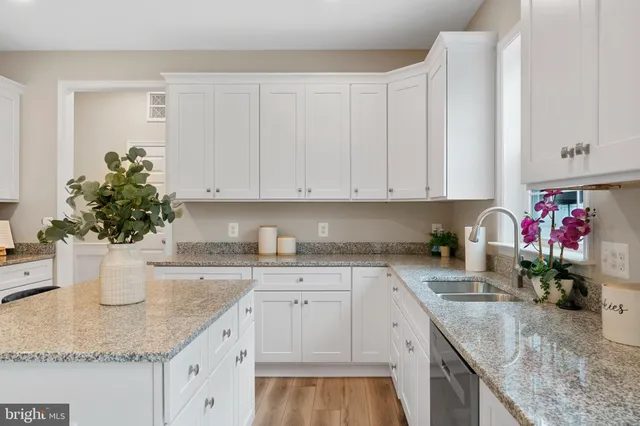 a kitchen with a white sink and cabinets