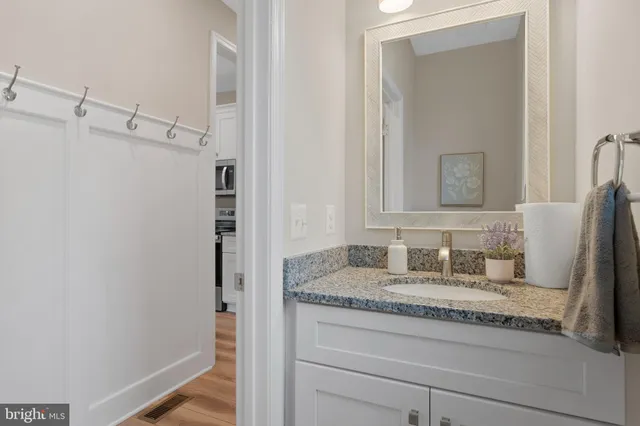 a bathroom with a granite countertop sink and a mirror
