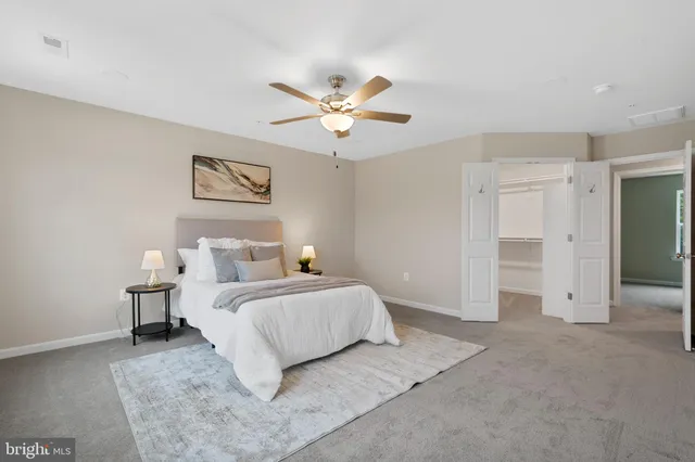 a bedroom with a bed and a ceiling fan