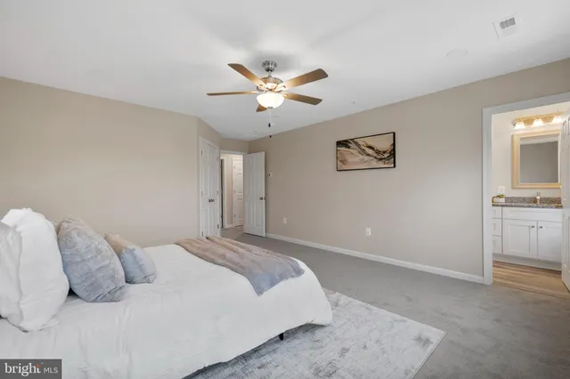 a bedroom with a large bed and a ceiling fan