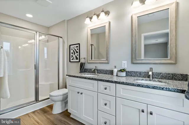 a bathroom with a granite countertop sink toilet and shower