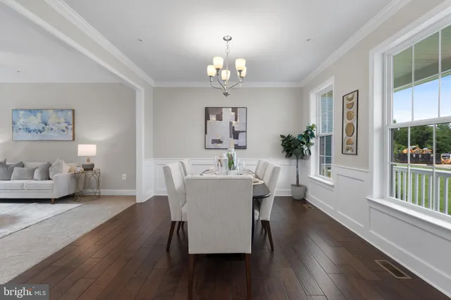 a view of a dining room with furniture a chandelier and wooden floor