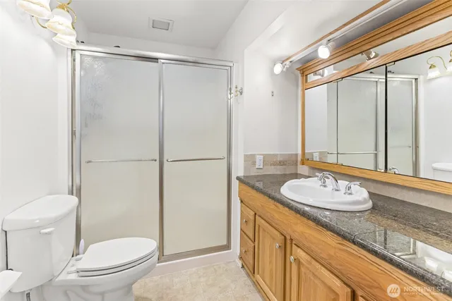 a bathroom with a granite countertop sink toilet and shower