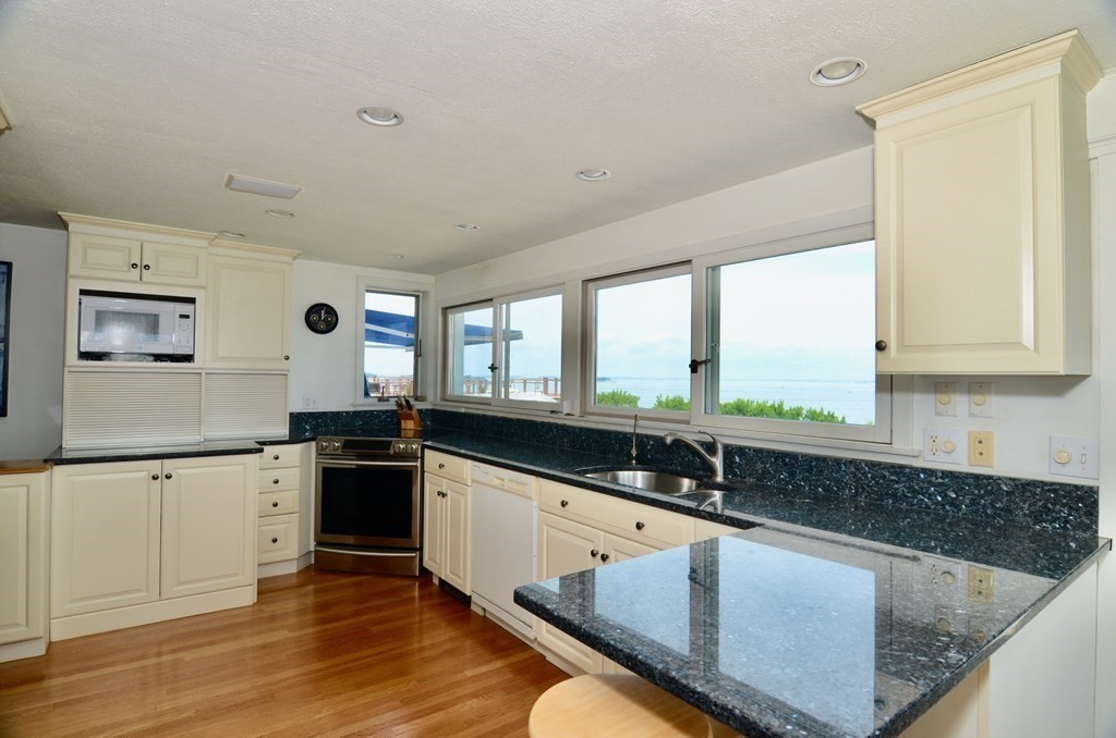 53 Harborview Road Hull, MA 02045 - Photo 4 of 21 a kitchen with granite countertop a sink and a stove top oven