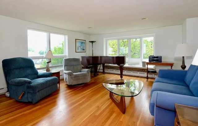 a living room with furniture a rug and a large window