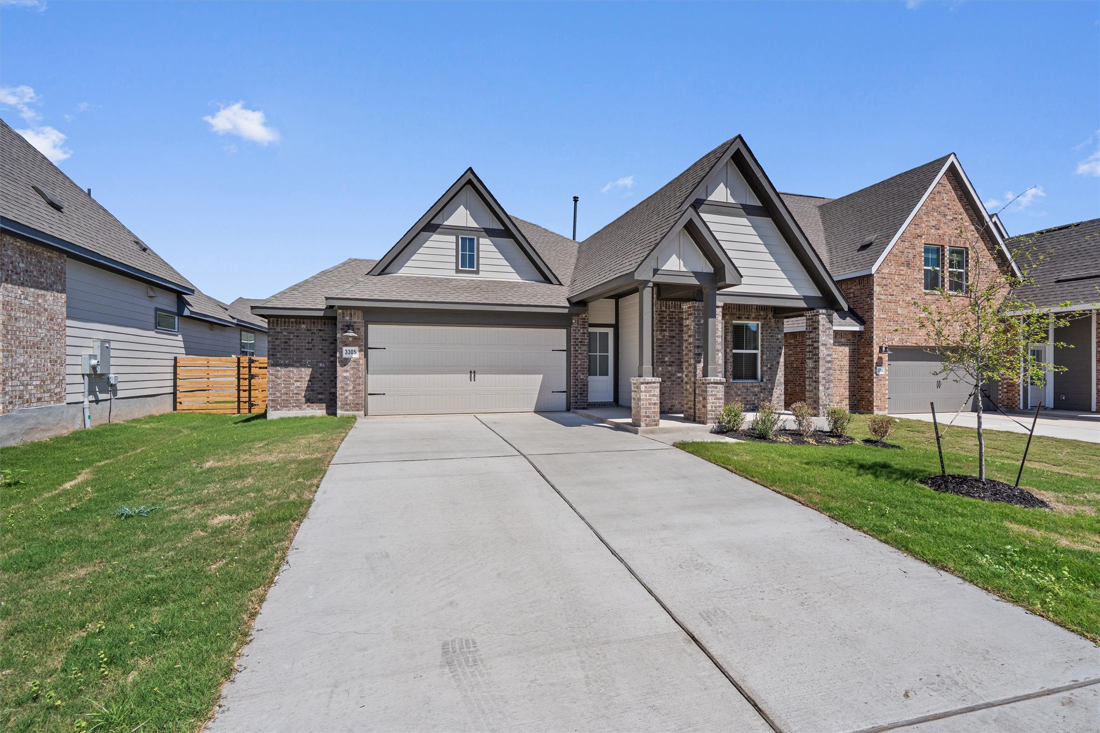 Craftsman inspired home with brick siding, driveway, roof with shingles, and an attached garage