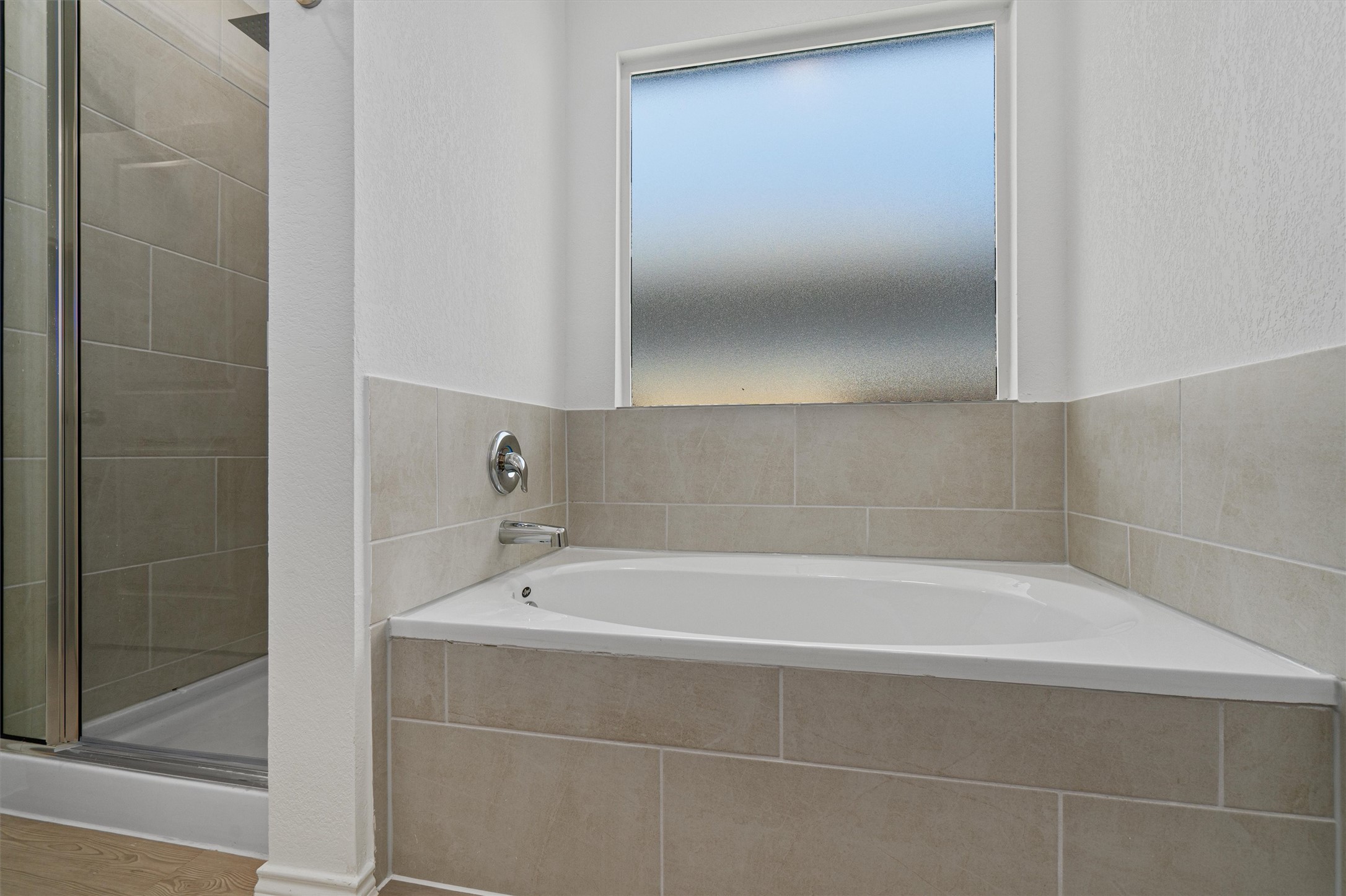 3305 Everett Kyle, TX 78640 - Photo 16 of 21 Primary Bathroom featuring a stall shower, a bath, and a textured wall