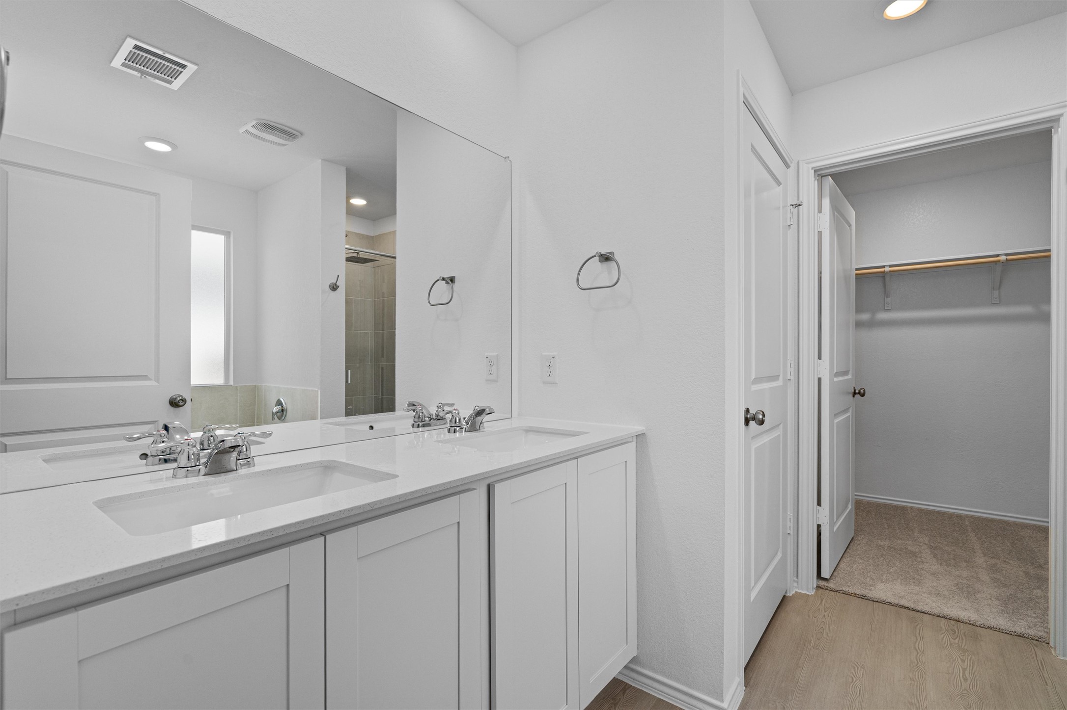 3305 Everett Kyle, TX 78640 - Photo 7 of 21 Primary bathroom with double vanity, a walk in closet, recessed lighting, a stall shower, and light wood-style flooring