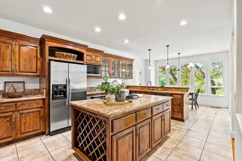 a kitchen with stainless steel appliances granite countertop a stove a sink dishwasher and a refrigerator