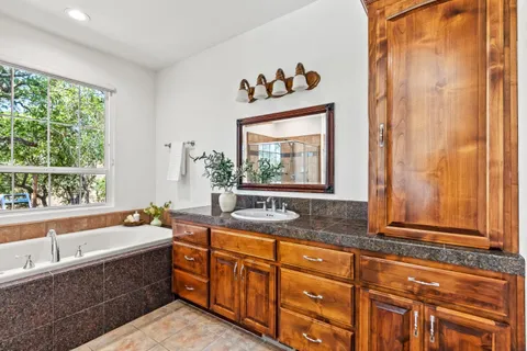 a bathroom with a sink mirror and a window