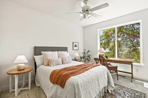 a bedroom with a bed and a large window