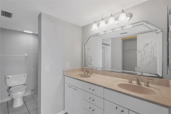 a bathroom with a granite countertop sink a toilet and a mirror