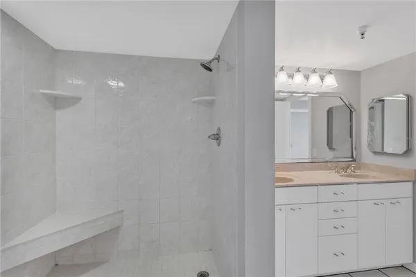 a bathroom with a double vanity sink mirror and bathtub